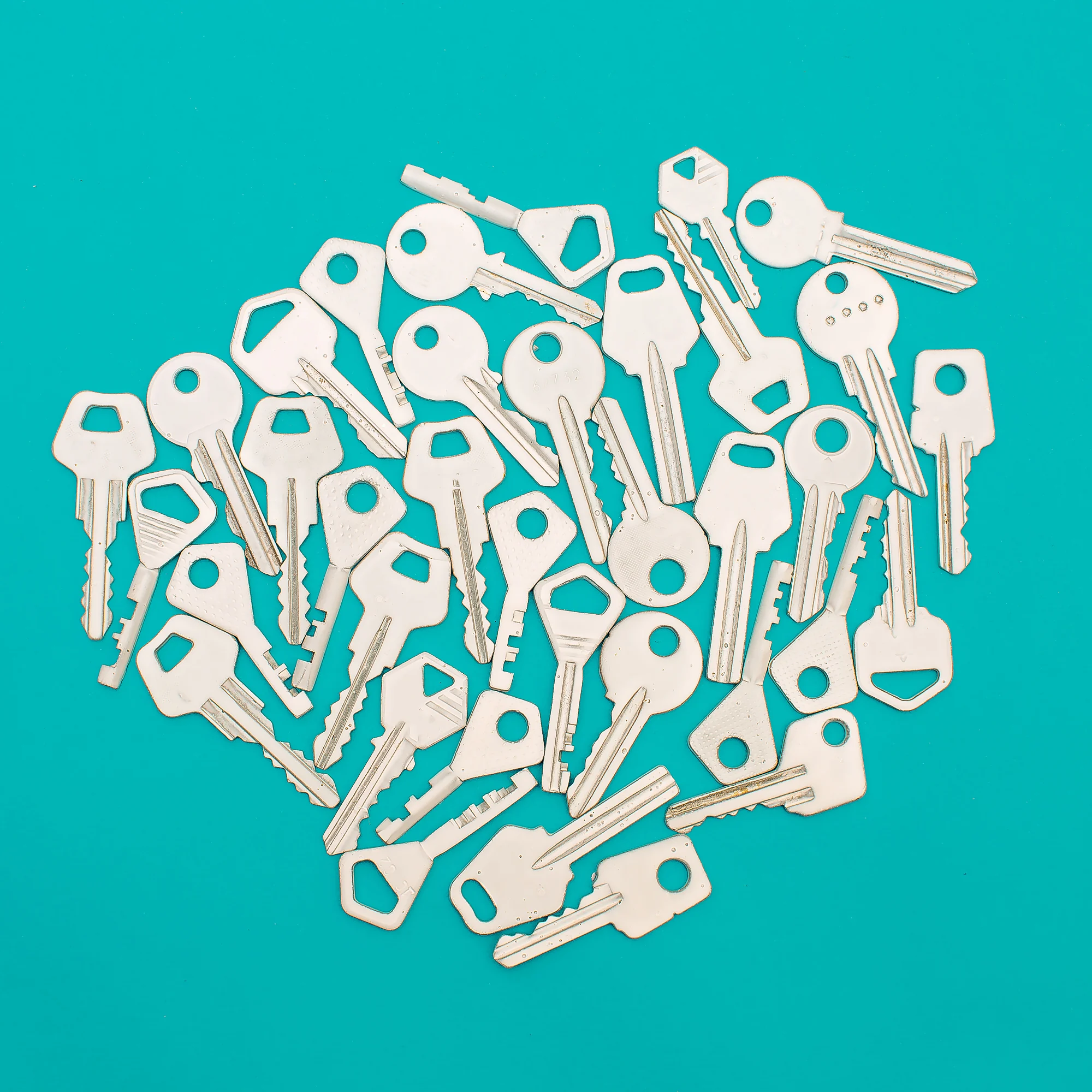 A collection of white keys arranged on a turquoise background A collection of white keys arranged on a turquoise background