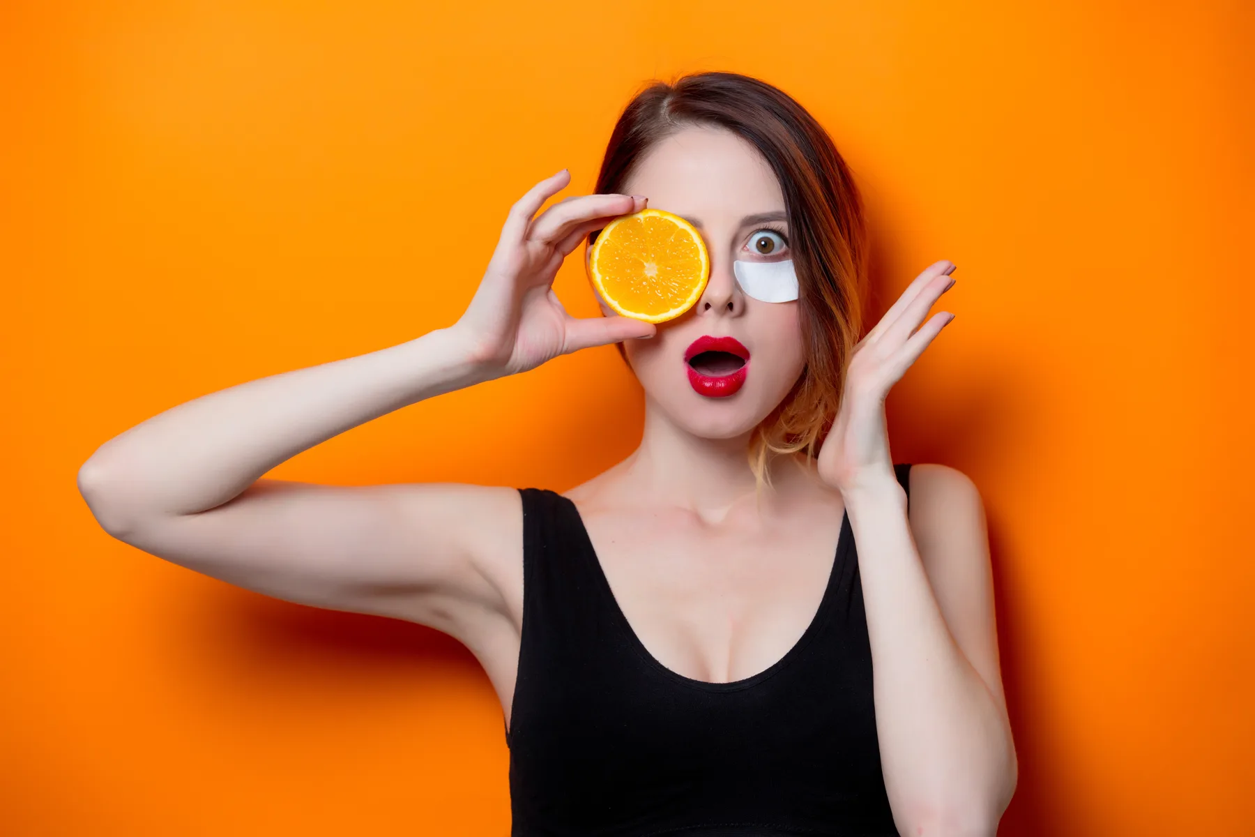 Woman with Orange Slice and Eye Mask Posing