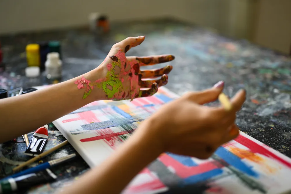 Person Painting Vivid Artwork with Colorful Hands Person Painting Vivid Artwork with Colorful Hands