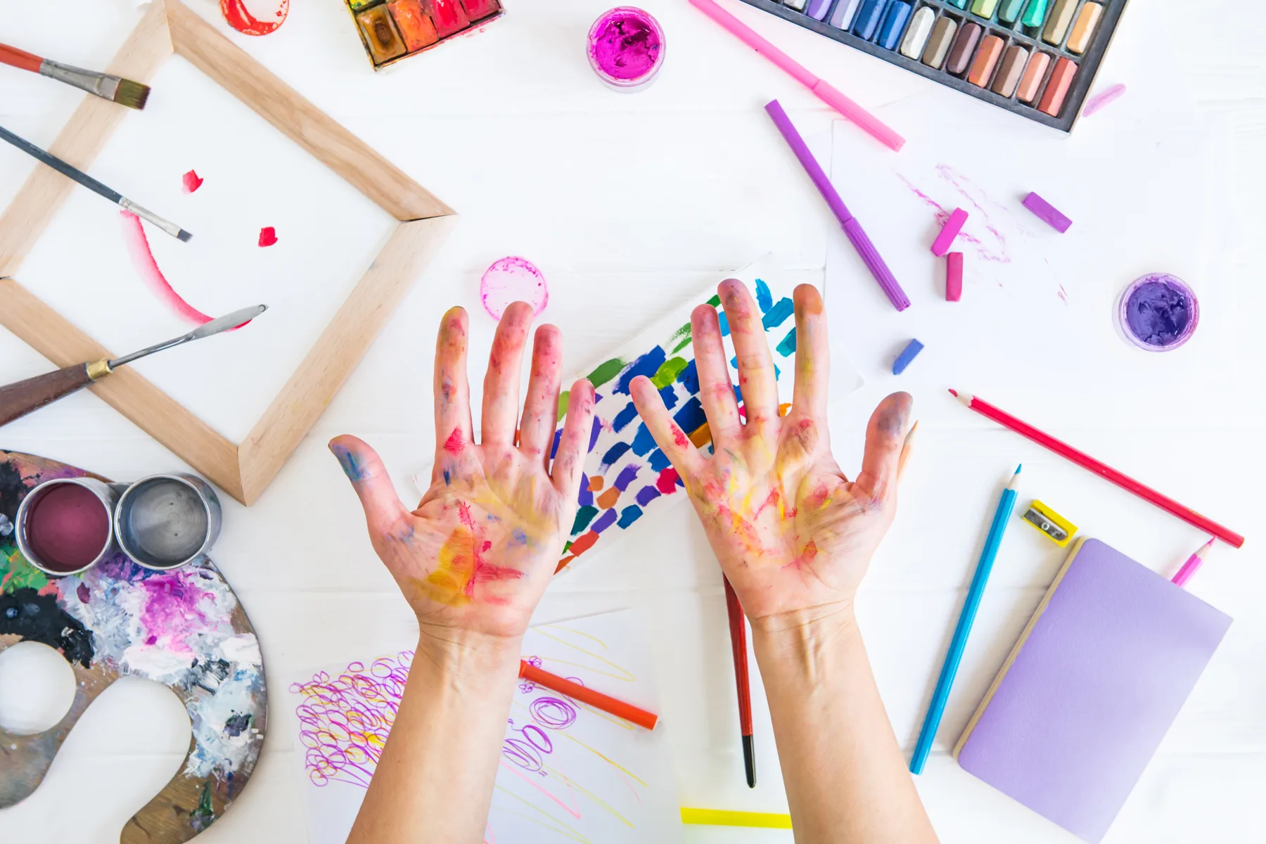 Hands Covered in Colorful Paint Surrounded by Art Hands Covered in Colorful Paint Surrounded by Art