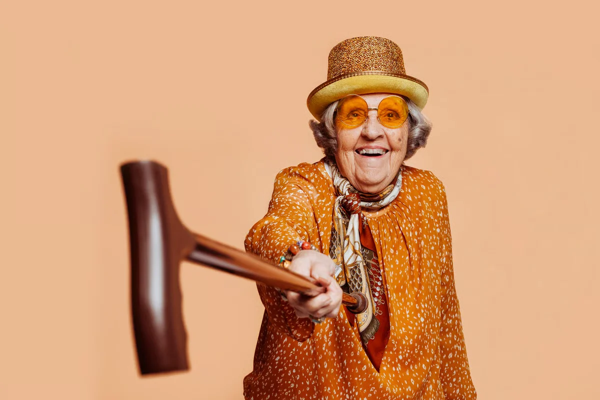 Playful senior woman reaching forward with a croquet mallet
