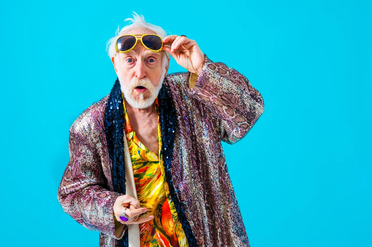 Expressive older man with yellow sunglasses and patterned styling