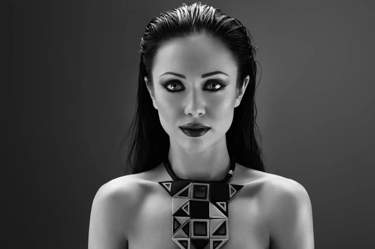 Black and white editorial portrait with geometric sculptural accessories